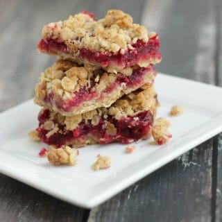 Stack of cramberry oatmeal bars on a white plate.