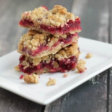 Stack of cramberry oatmeal bars on a white plate.