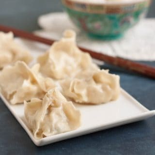 Image of Turkey Cabbage Potstickers on plate with chopsticks and rice in bowl.