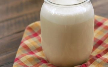 glass jar of homemade coffee creamer on a multi colored napkin