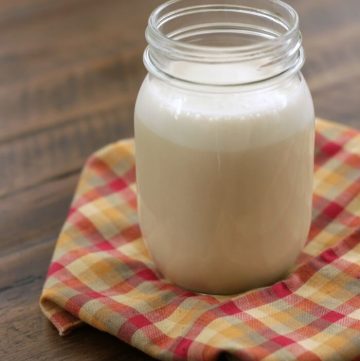 glass jar of homemade coffee creamer on a multi colored napkin