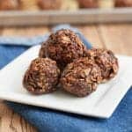 stack of No Bake Chocolate Cherry Snack Bites on a white plate on top of blue napkin.