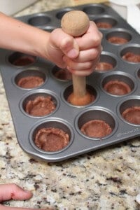 shaping cookie cups into a baking pan.