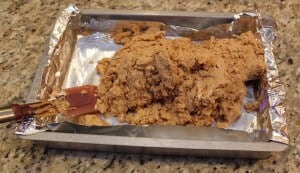 placing peanut butter fudge into a prepared baking pan