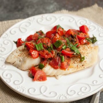 Super Simple Tomato Basil Topped Baked Fish tastes delicious and is budget friendly too! Get the recipe at MealPlanningMagic.com