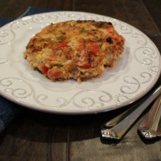 jalapeno salmon burger on a white plate with silverware on right side