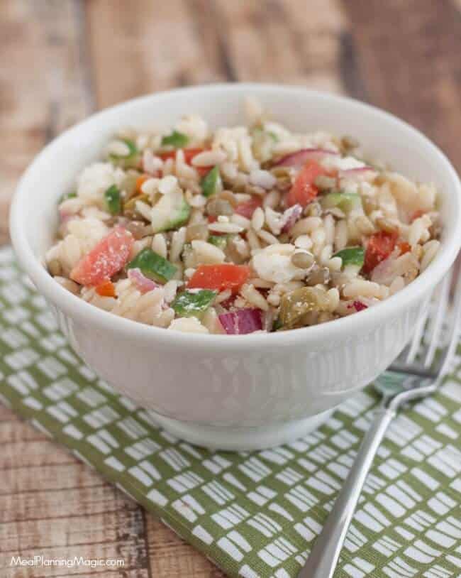 This Greek Lentil Orzo Salad a nutritious and economical way to enjoy fresh vegetables and lentils. It's make ahead too! Recipe at MealPlanningMagic.com