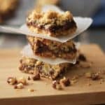 Close up image of stacked Creamy Chocolate Oatmeal Bars on wooden plank.