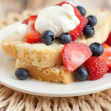 Image of Wonderful Lightened Up Pound Cake with Berries and Cream layered on a plate and a straw place mat.