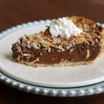 side view of slice of German Chocolate Sweet Cream Pie on a white plate and a blue plate