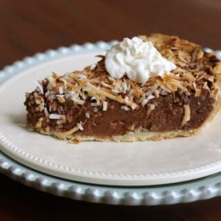 side view of slice of German Chocolate Sweet Cream Pie on a white plate and a blue plate