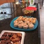 Different food on platters on a black counter in a kitchen.