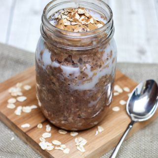 Glass jar containing ingredients mixture of Cinnamon Chocolate Peanut Butter Overnight Oats.