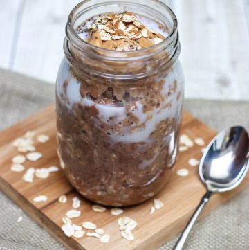 Glass jar containing ingredients mixture of Cinnamon Chocolate Peanut Butter Overnight Oats.