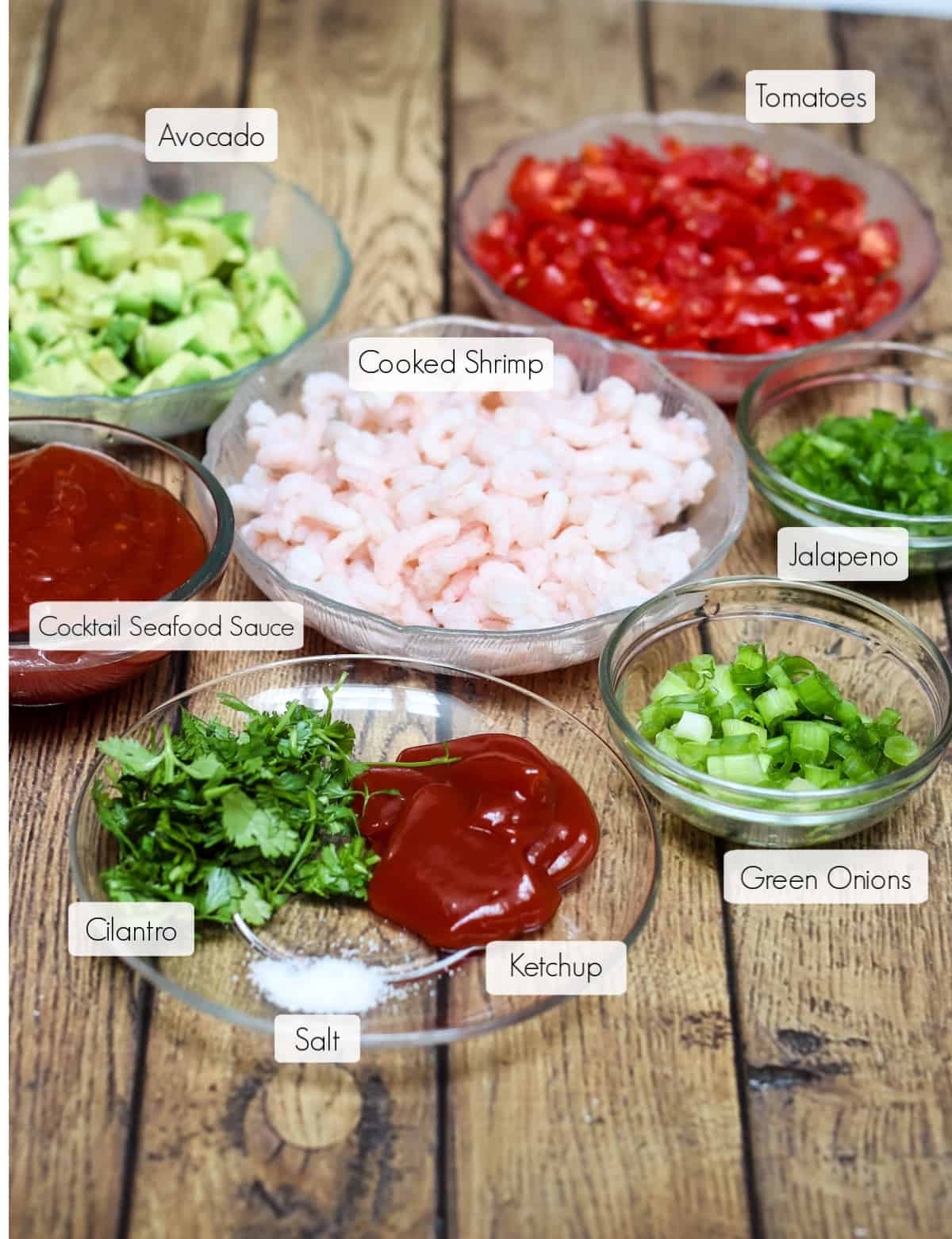 Ingredients in bowls for Shrimp Avocado Salsa with each labeled. 