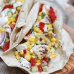 image of fish tacos with avocado, tomato and corn salsa in tortilla