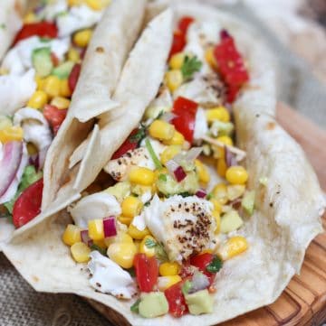 image of fish tacos with avocado, tomato and corn salsa in tortilla