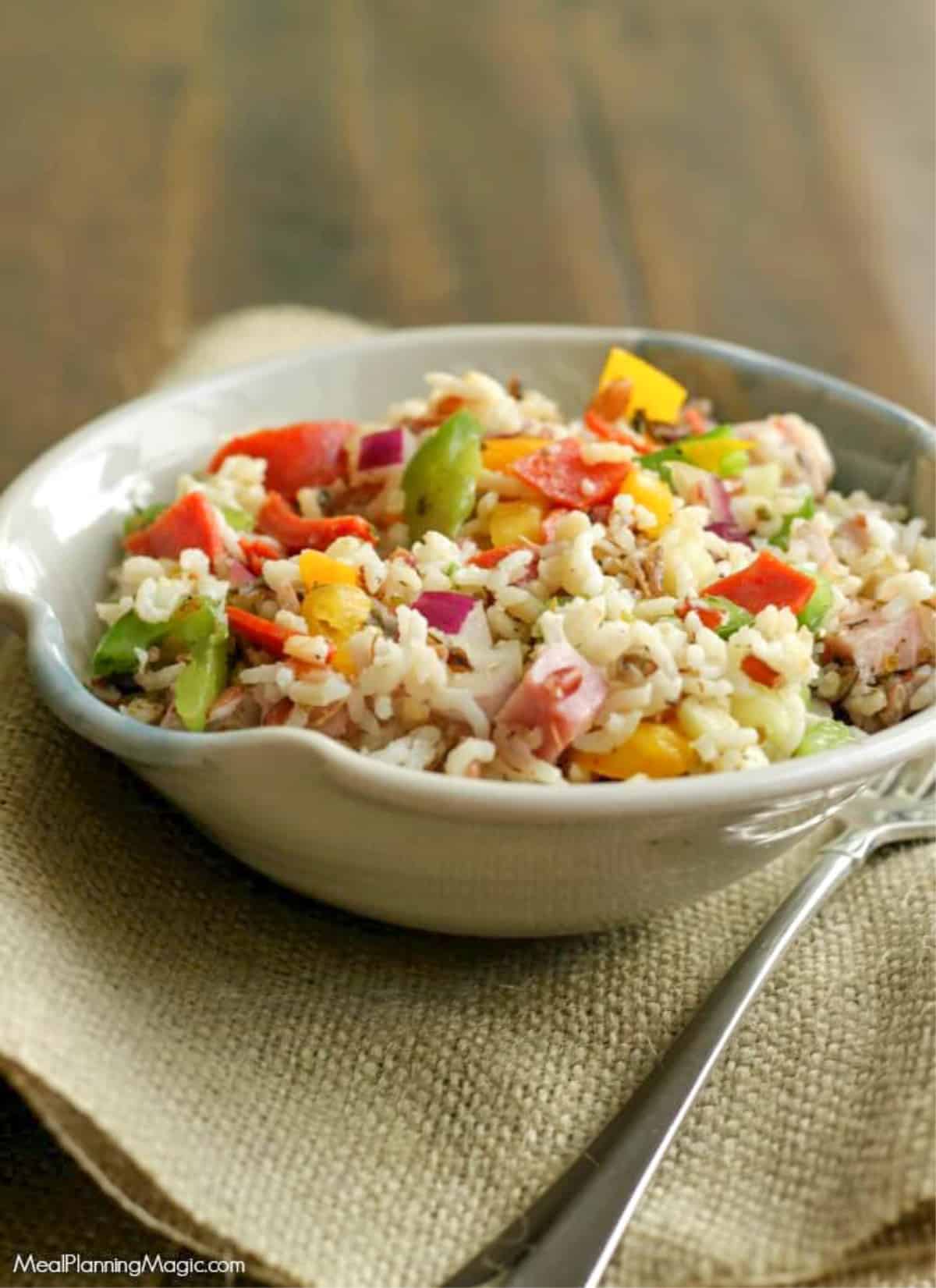 Italian Vegetable Wild Rice Salad in a pottery bowl on burlap napkin. 