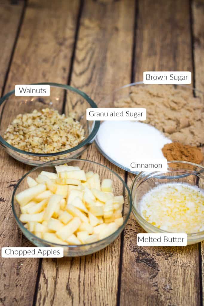 Labeled ingredients in bowls for apple cinnamon rolls filling.