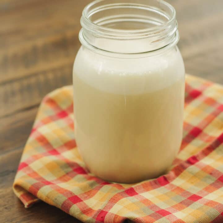 homemade coffee creamer in glass jar on multi colored napkin.