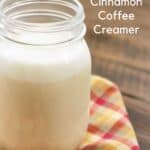 Glass jar of homemade cinnamon vanilla coffee creamer on a multi colored napkin with text overlay.