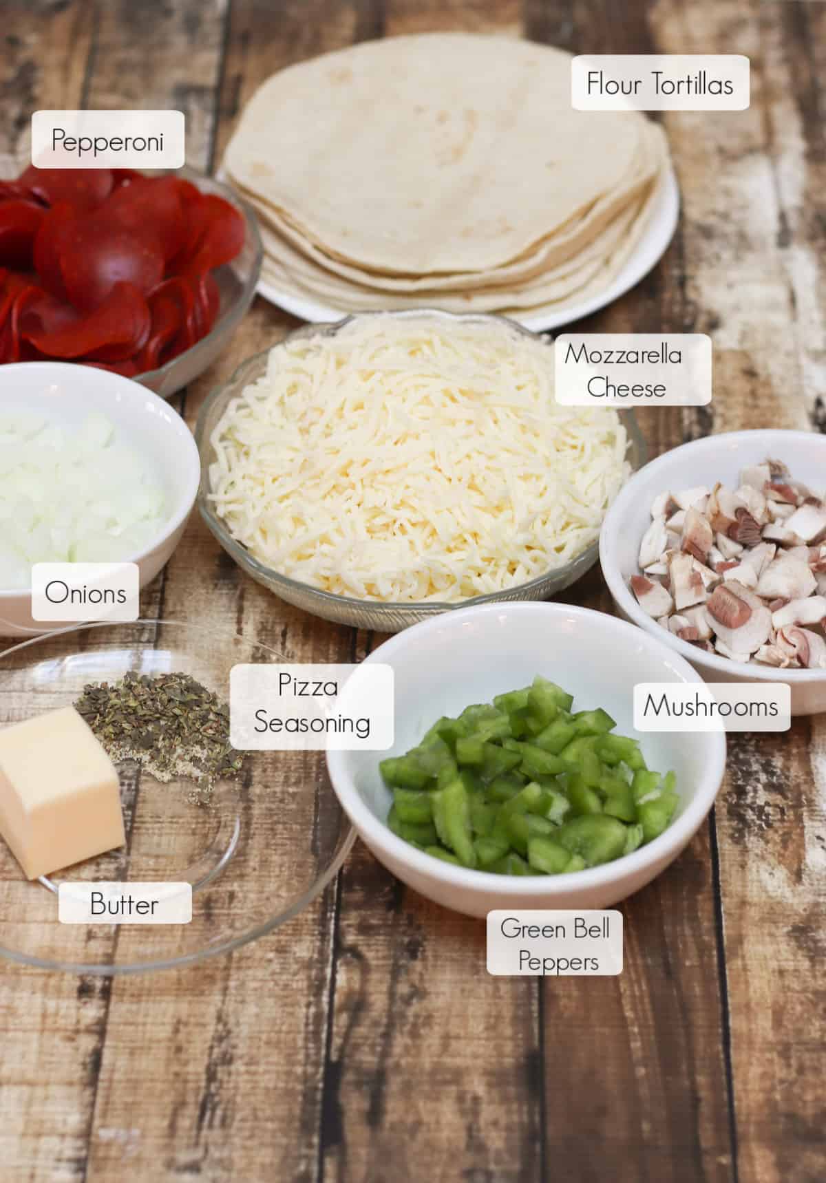 Ingredients in bowls with labels for making Pepperoni Pizza Quesadillas. 