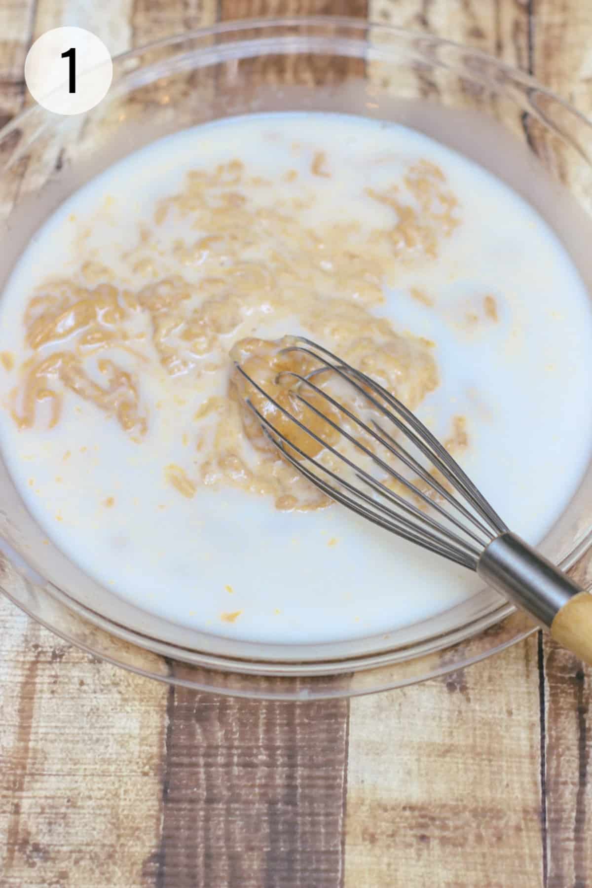 Peanut butter, egg and coconut milk being whisked in a pie plate. 
