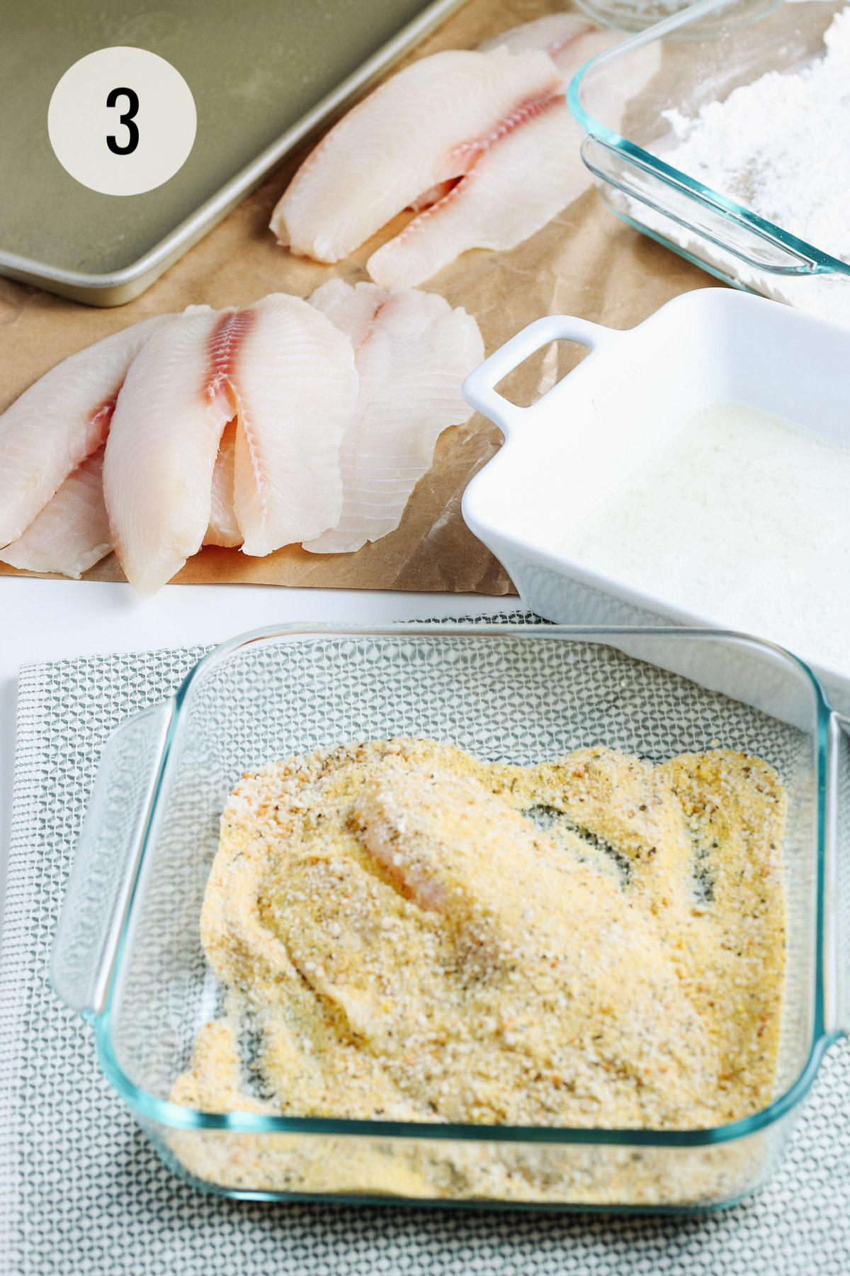 Tilapia fish filet in cornmeal mixture for breading and extra fish, flour and egg whites in dishes for extra dipping. 