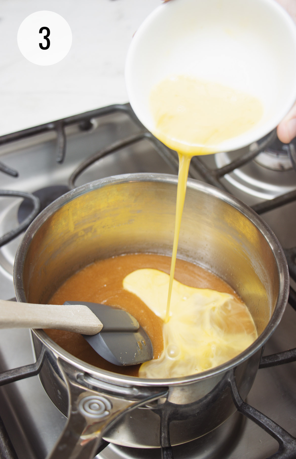 Beaten eggs being poured into saucepan with blondie bars batter mixture. 