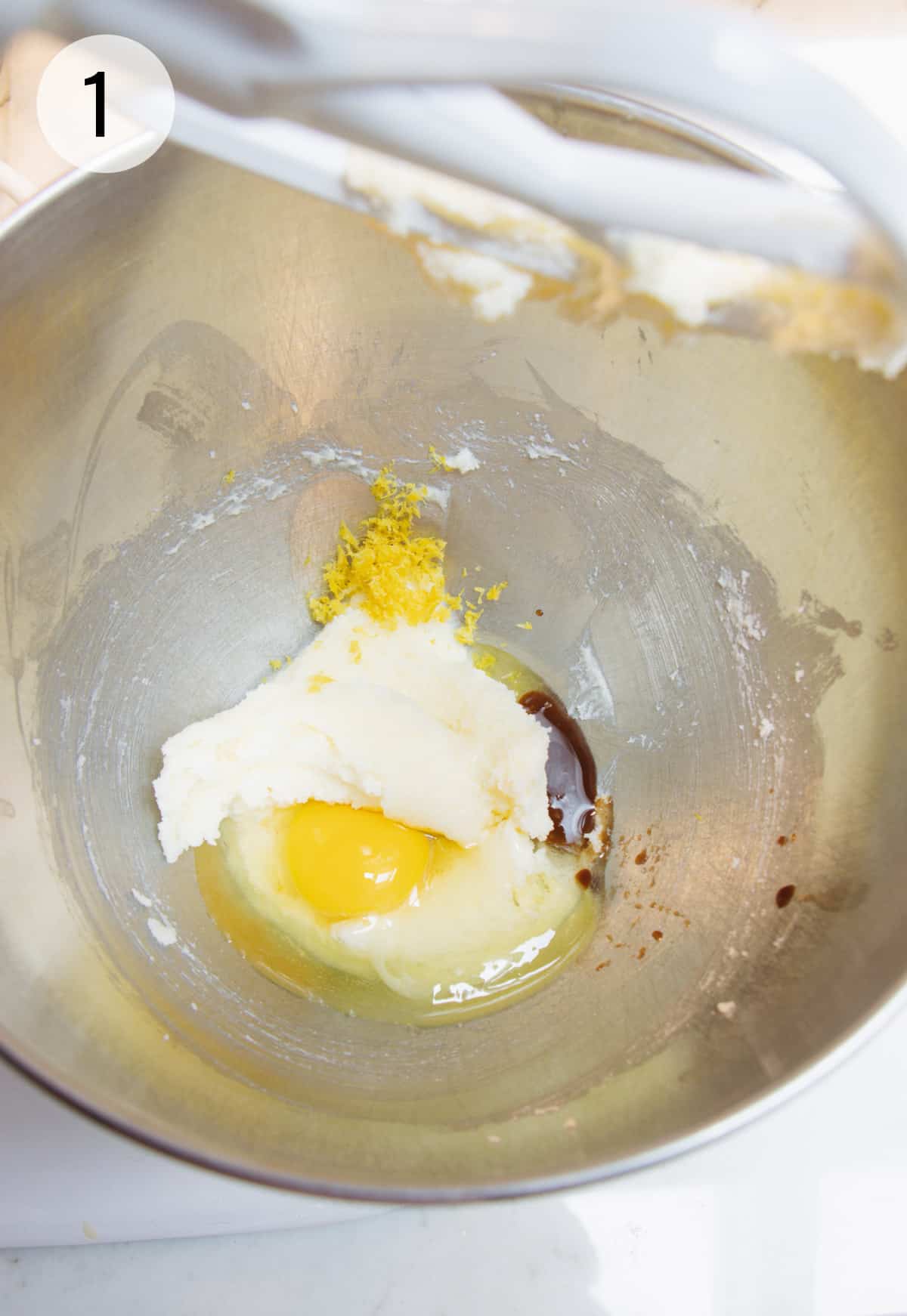 Creaming butter, egg, vanilla and lemon zest in a metal mixing bowl. 