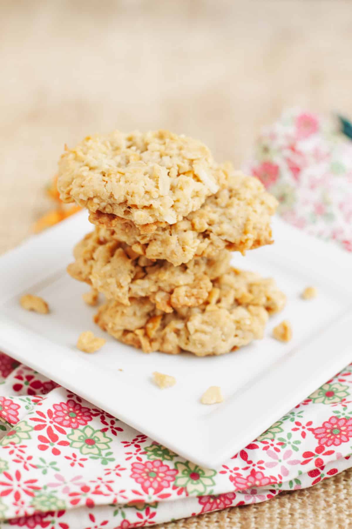 Stack of Cracker Jack Rice Crispie Cookies on a square white plate on a pink, green and white napkin. 