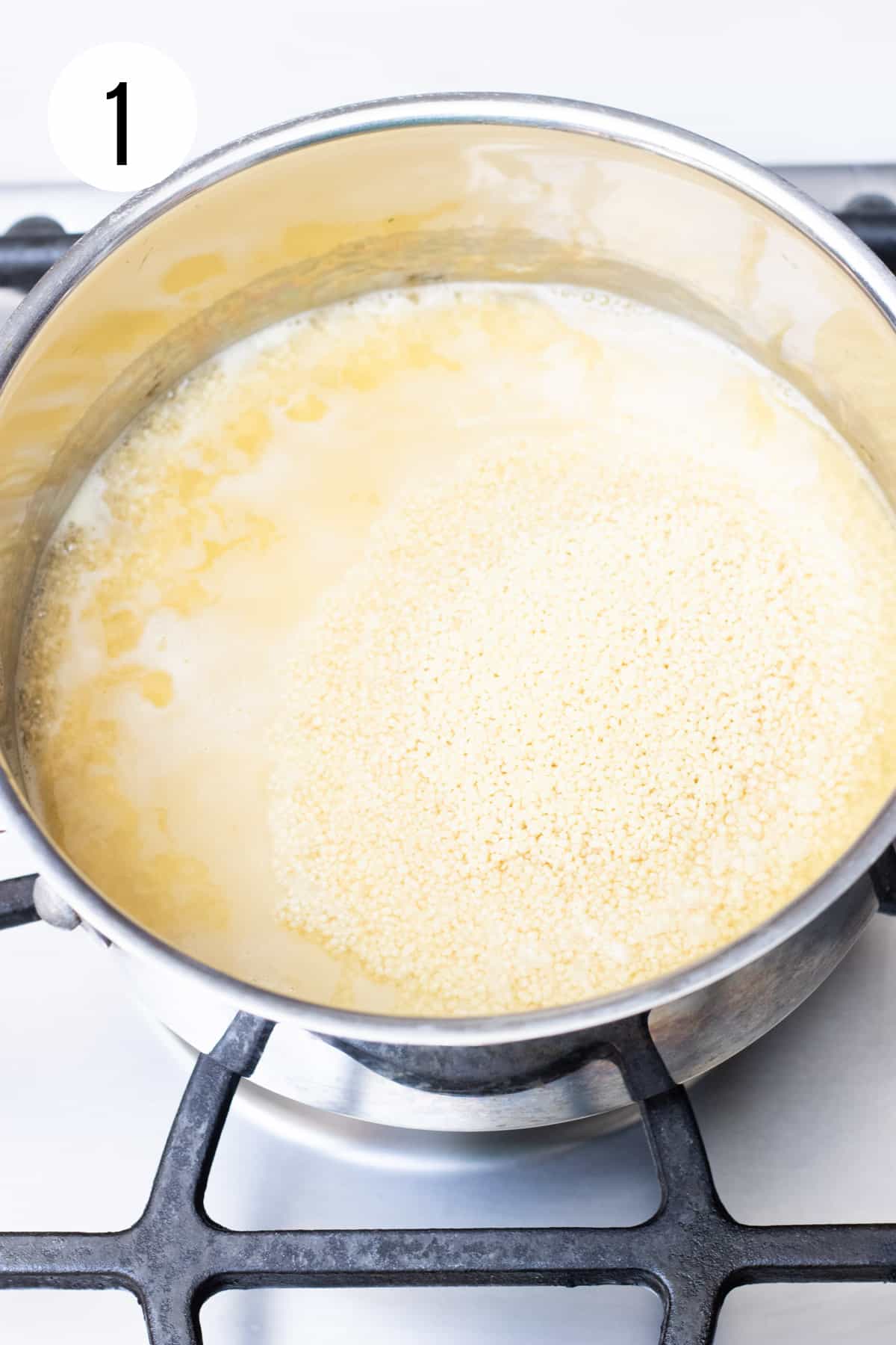 Silver saucepan with chicken broth and couscous cooking. 