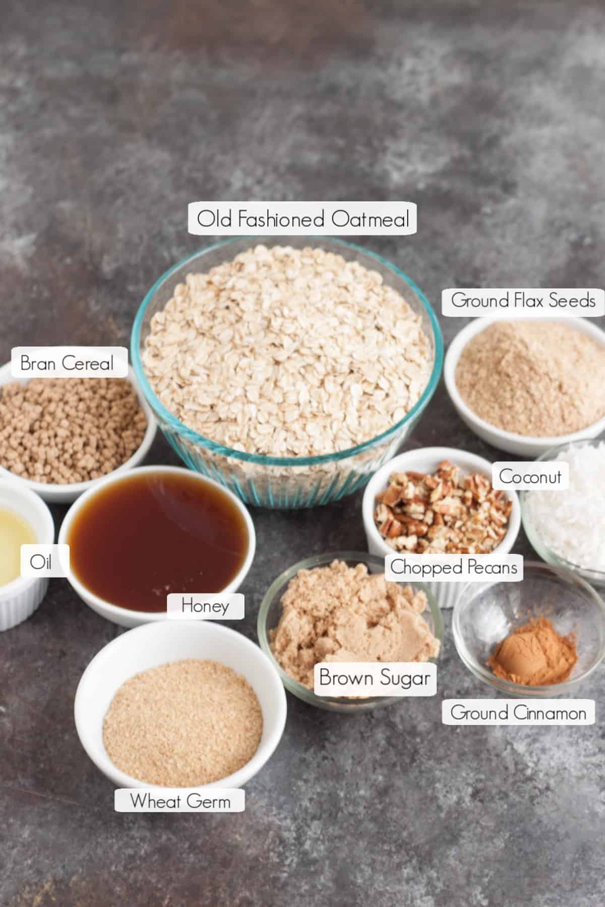 Labeled bowls with ingredients to make homemade honey cinnamon granola. 