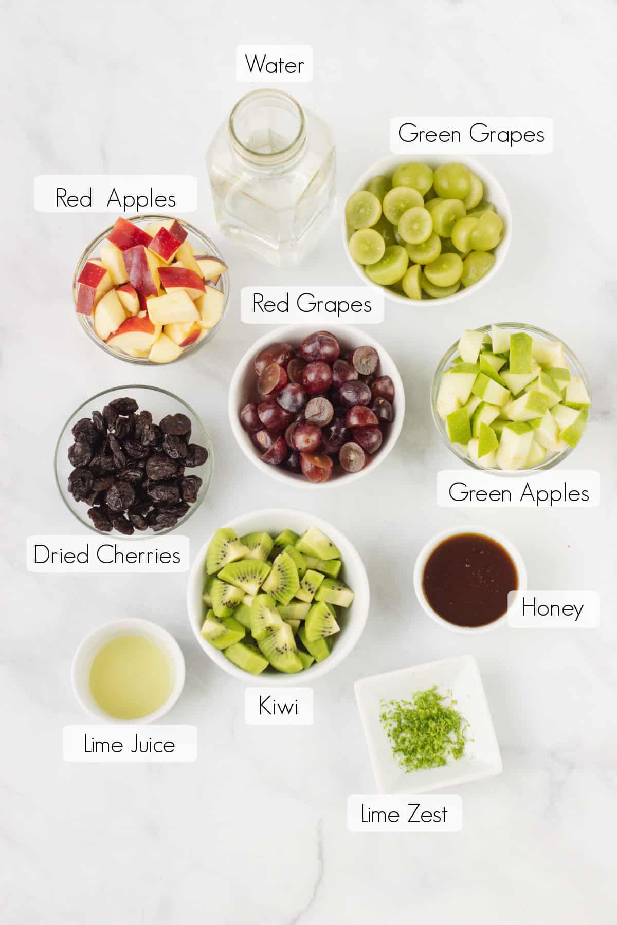 Labeled ingredients for Holiday Fruit Salad in bowls.