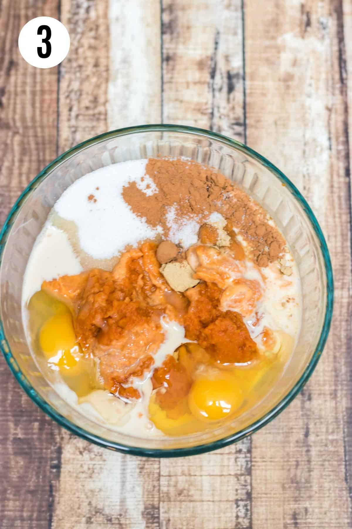 Glass bowl with canned pumpkin, eggs, ground cinnamon, ground cloves, sugar and evaporated milk to make pumpkin pie bars filling. 